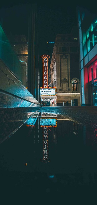 The famous Chicago Theatre sign reflected on a flooded Chicago sidewalk. Photo by Guillermo Arroyo from Pexels.