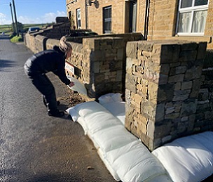A wall of FloodSax alternative sandbags protecting a house from floodwater